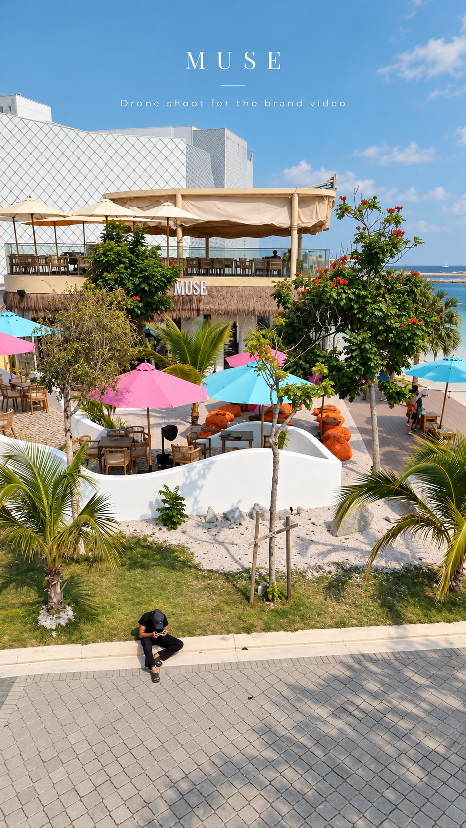 Overhead view of MUSE’s outdoor space, framed by greenery and colourful parasols.