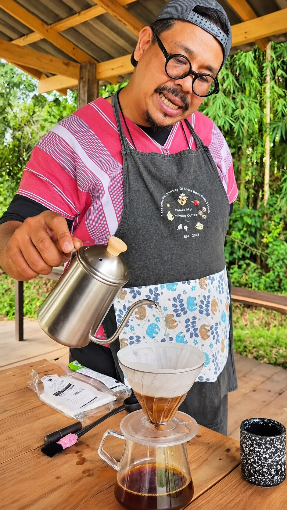 Coffee farmer demonstrating pour-over brewing at a Chiang Mai coffee farm